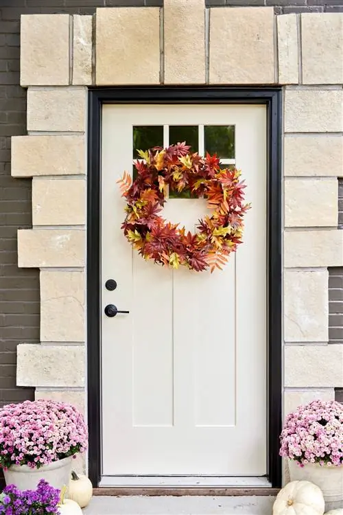 Венок из осенних листьев на двери кремового цвета