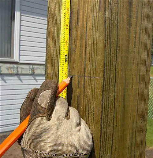 используя карандаш и рулетку, чтобы отметить линию разреза на стойке