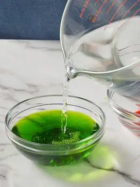 добавление уксусной воды в миску с зеленым красителем
