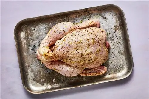 приправленная сырая курица на противне
