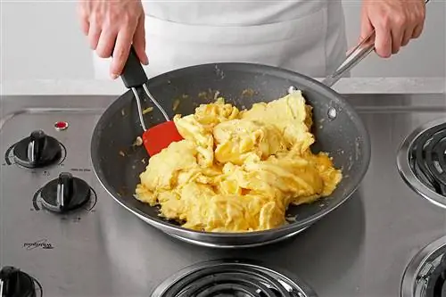 Подъем и переворачивание частично приготовленной яичной смеси при приготовлении яичницы-болтуньи.