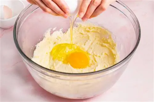 добавление яиц к сливочному маслу и сахару в миске