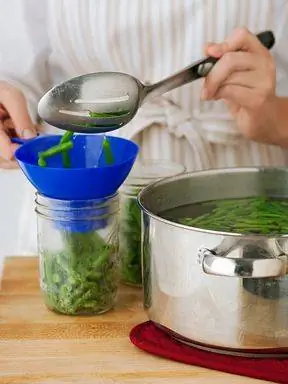 наполнение банки продуктами с помощью воронки