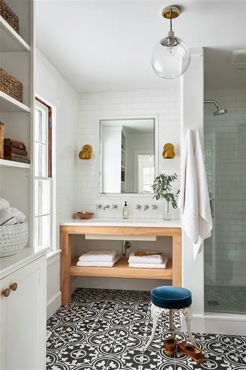 белая ванная комната с черно-белой плиткой на полу