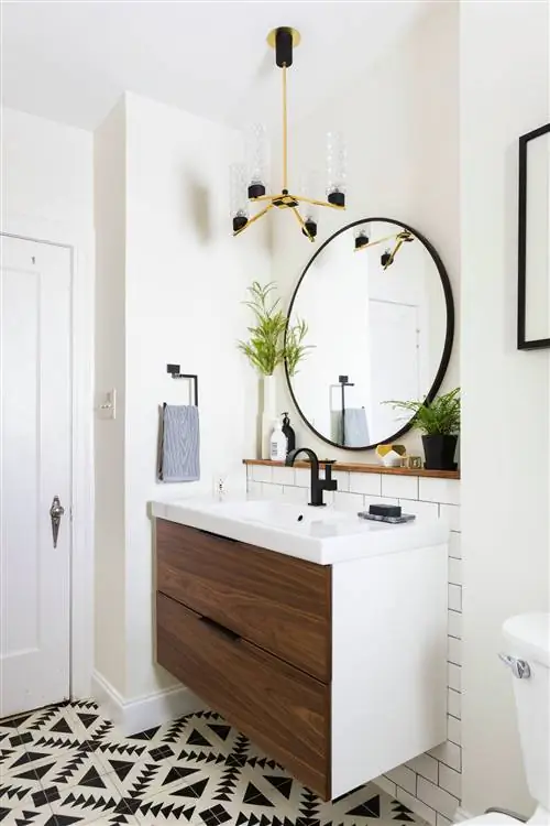 черно-белая напольная плитка в ванной комнате с черным круглым зеркалом