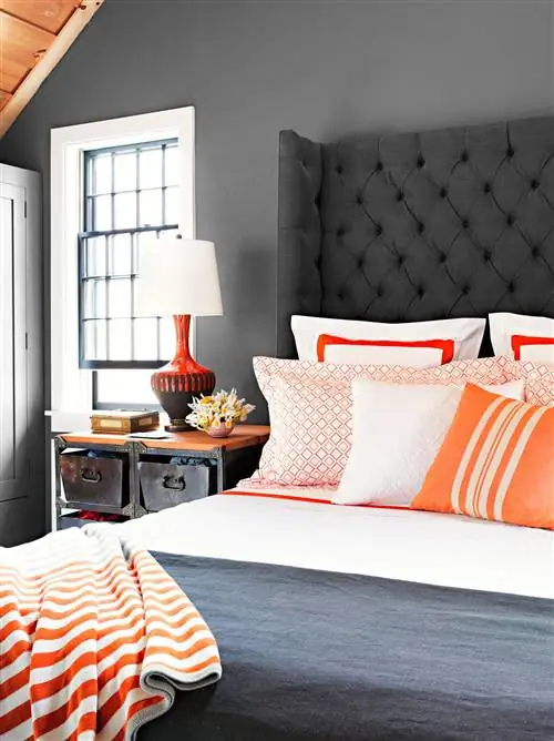 спальня с темными стенами и высоким изголовьем