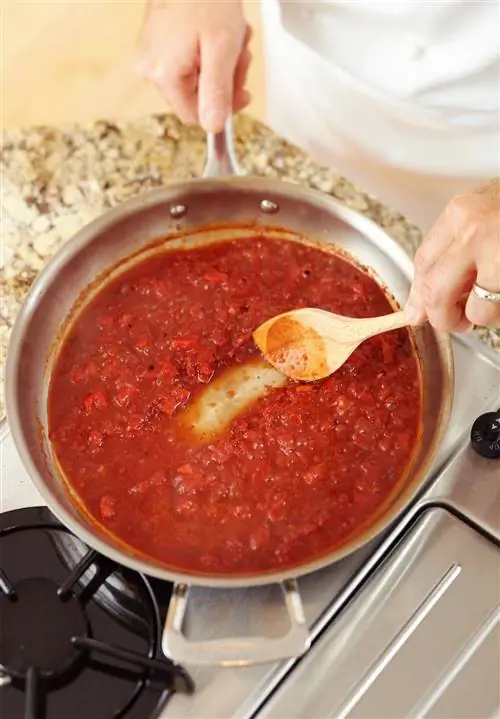 Перемешивание томатного соуса на плите