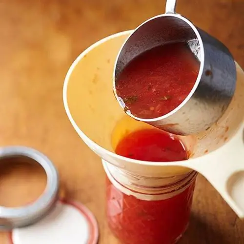 Переливание сальсы в консервную банку с помощью воронки