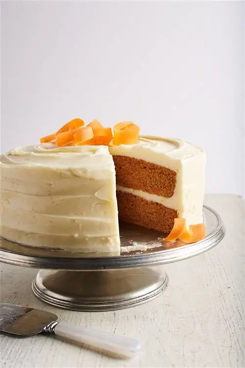 Рецепт морковного торта на подставке Silver Cake с вырезанным ломтиком. Морковные ленты сверху.