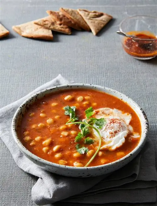 Лаблаби (тунисский суп из нута) в белой миске с яйцом-пашот и кинзой