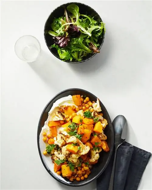 Жареный на воздухе нут и тыква на черной тарелке с гарниром