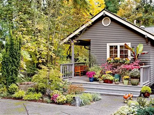 Темно-серый дом с крыльцом, полным растений