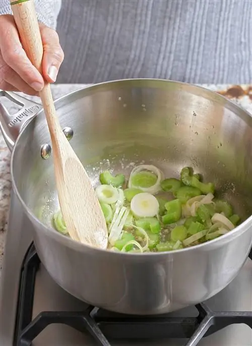 приготовление пищи лук-порей сливочное масло сотейник деревянная ложка плита