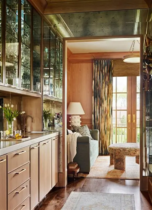 деревянная кухня со стеклянными шкафами и отражающей плиткой