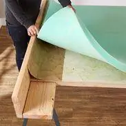 прикрепите пенопласт аэрозольным клеем к внутренней части каркаса изголовья