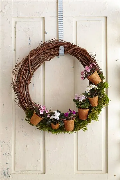 Цветочные горшки на венке из веток, висящих на двери