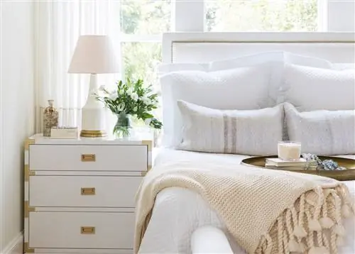 спальня с белым постельным бельем и мебелью