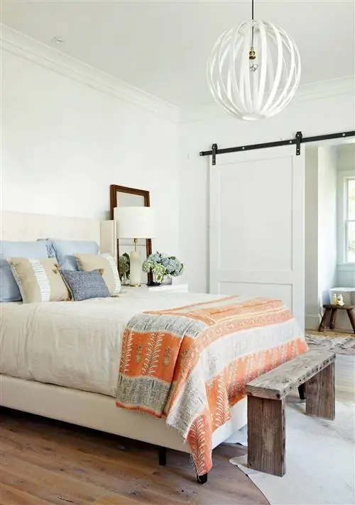 синие и оранжевые акценты на белой кровати