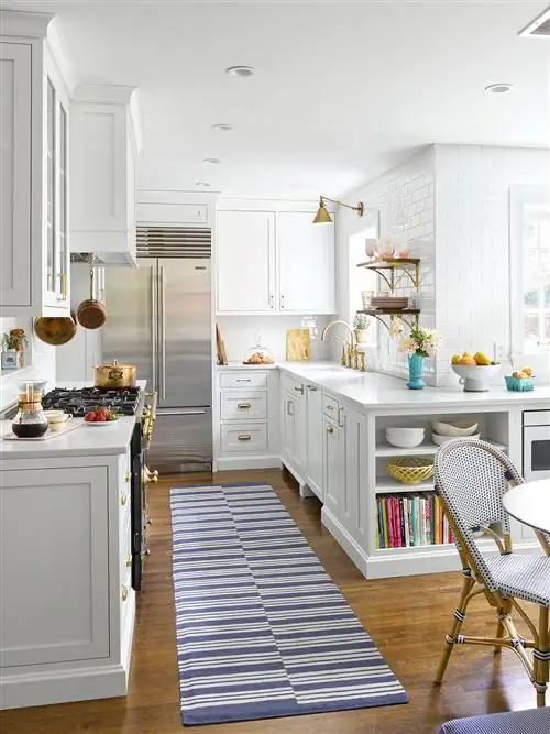 Кухня с белыми шкафами и полосатым ковриком