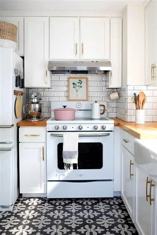 Кухня с белой плитой и узорчатым ковриком