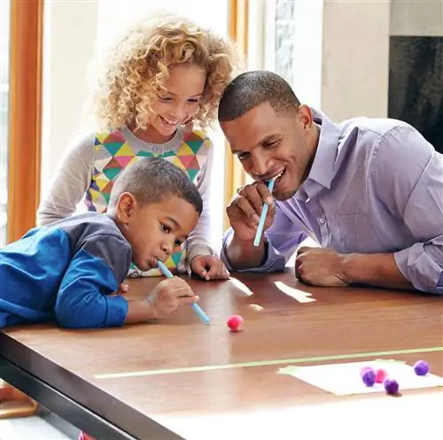 семья дует в соломинку гонка с помпонами