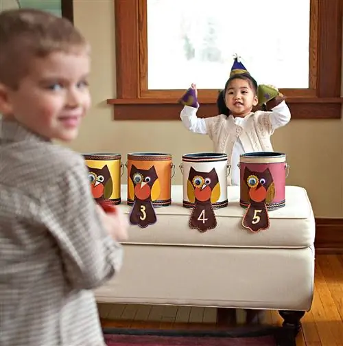 дети бросают шарики в украшенные банки с краской