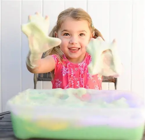 девушка играет с ванной из радужной пены