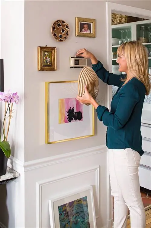 женщина проверяет когда-то спрятанный термостат на стене