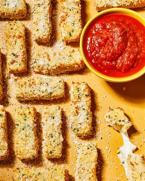 Палочки из моцареллы и соус маринара на желтой тарелке