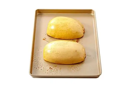 половинки тыквы-спагетти лежат лицом вниз на противне