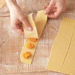 накройте полоску теста с начинкой для равиоли