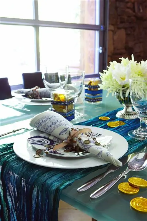 сервировка ханукального стола с золотыми монетами и темно-синим шарфом