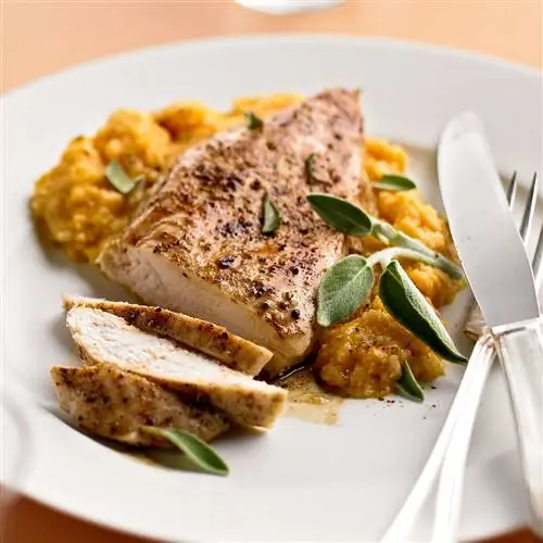 Жареная курица с корицей и тыквенно-шалфейной крупой на тарелке