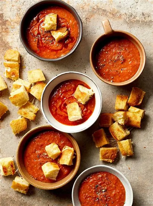 тарелки супа из свежих помидоров с жареными сырными гренками на сковороде