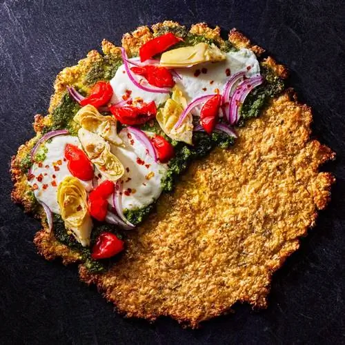 Пицца с корочкой из цветной капусты и розмарина, наполовину покрытая соусом песто, сыром и овощами Пицца с корочкой из цветной капусты и розмарина, наполовину покрытая соусом песто, сыром и овощами