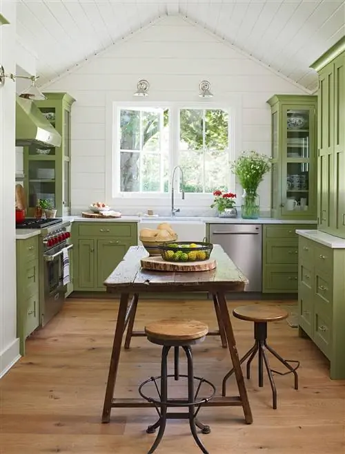 кухня из зеленого дерева с наклонным потолком и деревенским столом