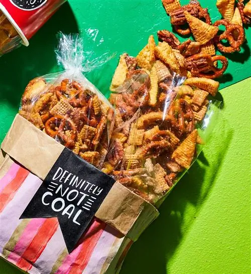 Cinnamon Churro Snack Mix выливается из красных контейнеров на зеленом фоне