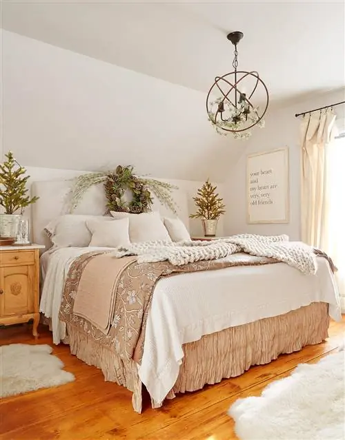 Нейтральная спальня в фермерском доме с вечнозеленым венком на изголовье