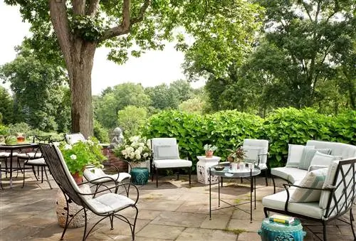 шезлонги с белыми подушками на террасе каменного сада