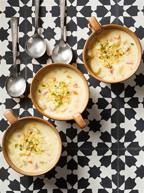Картофельный суп с гребешком и ветчиной в мисках с ложками