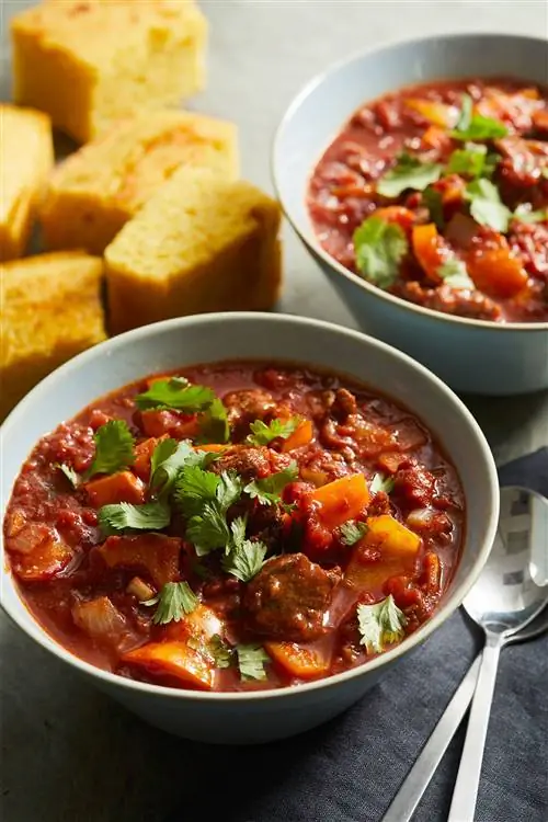 Скороварка сладкое и острое тушеное мясо в серых мисках с кукурузным хлебом