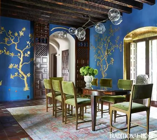 яркая синяя столовая с зелеными стульями и деревянным столом в испанском колониальном доме