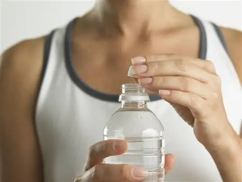 Женщина открывает бутылку с водой