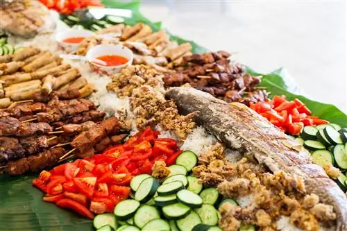 целая вареная рыба поверх овощей и мяса