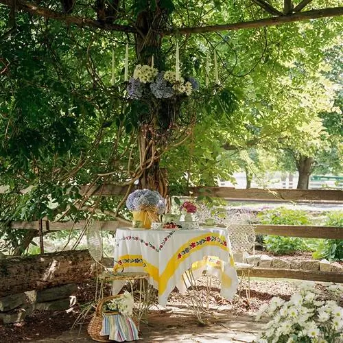 небольшой столик для террасы под деревянным навесом в саду