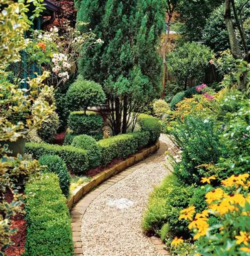 изогнутая гравийная дорожка через сад