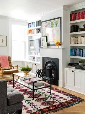 встроенные полки, окружающие черный камин и каминную полку