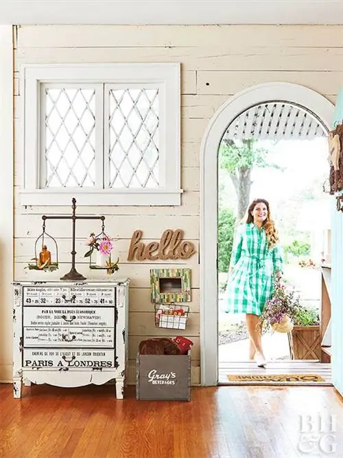 женщина в зеленом пледе входит в дом