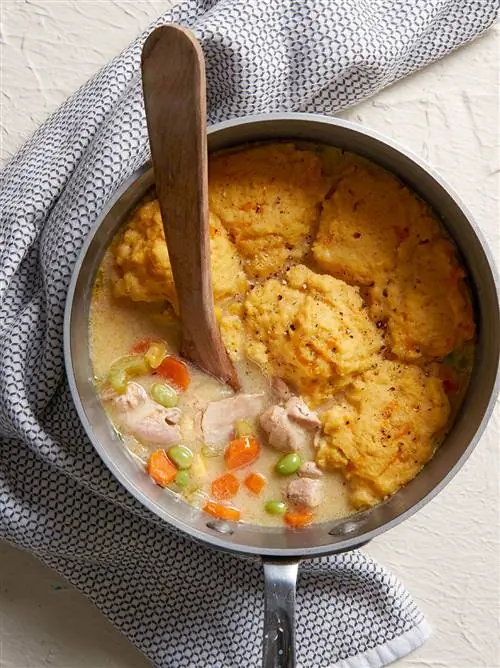 Куриное рагу с кнедликами из кукурузной муки горшок с деревянной ложкой