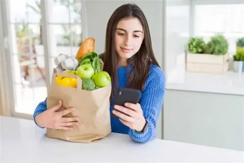 Женщина заказывает продукты по мобильному телефону Женщина заказывает продукты по мобильному телефону